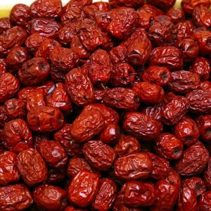 A pile of dried red Chinese dates, showcasing the harvest of Ziziphus jujuba fruit, rich in color and texture.